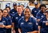 Diverse USPS employees working together in a postal facility.