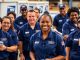 Diverse USPS employees working together in a postal facility.