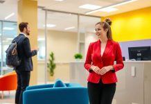 Friendly receptionist welcoming visitors in a modern office.