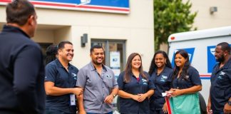 USPS employees engaging with customers outside a post office.