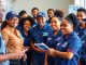 Postal workers assisting customers at a busy post office.